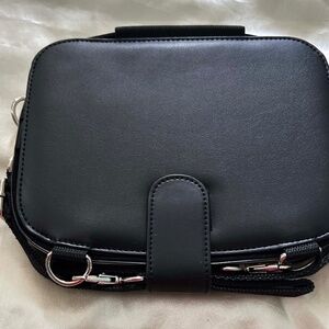 SQUARE BAG CONVERTS TO A BACKPACK, BLACK FABRIC, LINED, TWO STRAPS, FLAP CLOSURE